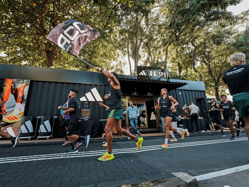 Runners passing the black adidas Runspot container on the Lagoa, Rio de Janeiro